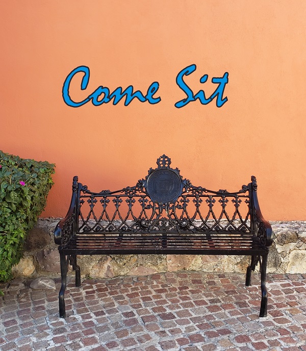A wrought iron bench leading to downtown San Miguel Square